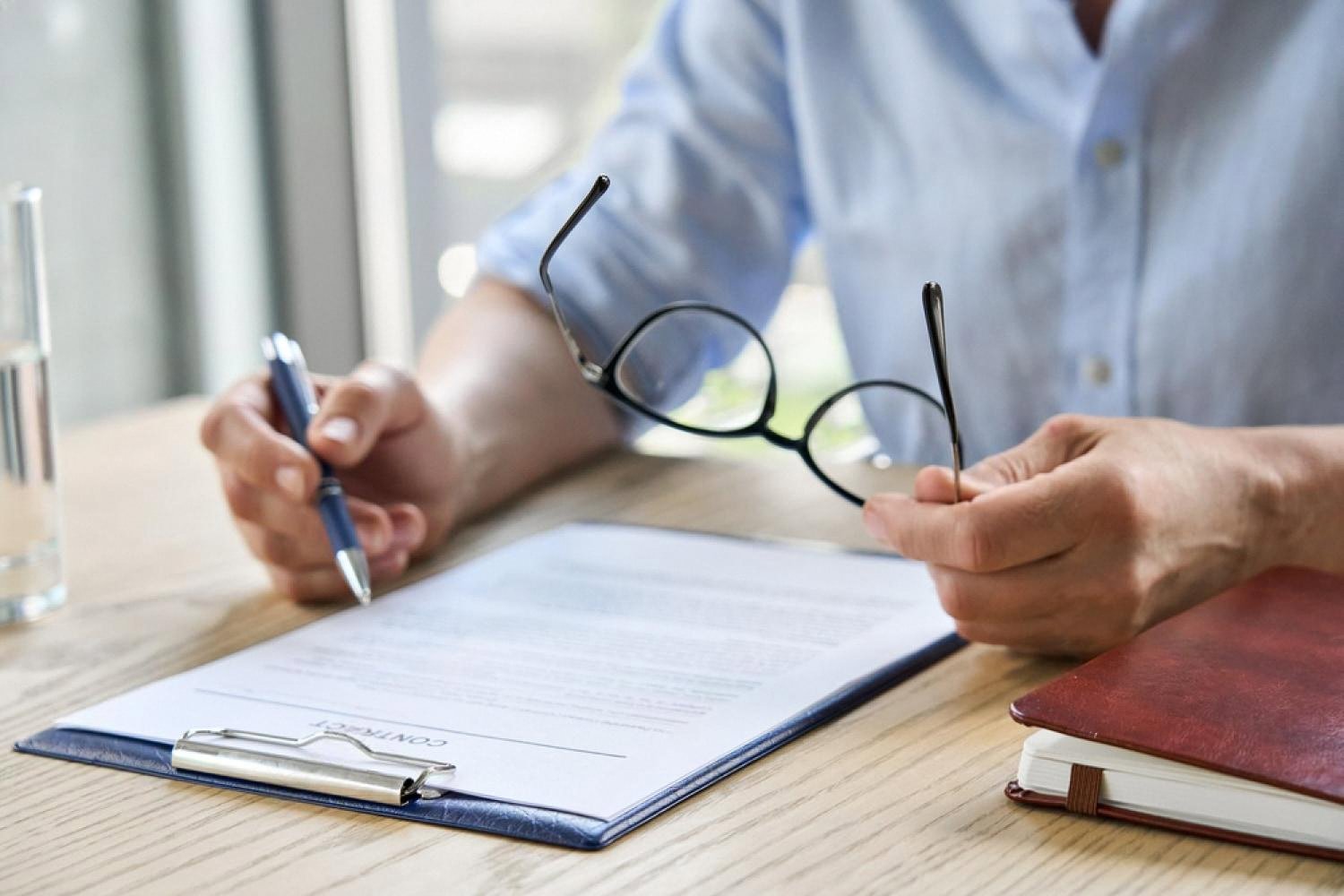 HR manager reviewing an employment contract with pen and glasses in a UAE office